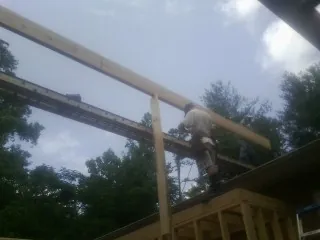 Carpenter setting a ridge beam over a new addition frame — Ice Dam Removal by Roofing Brothers in Gifford