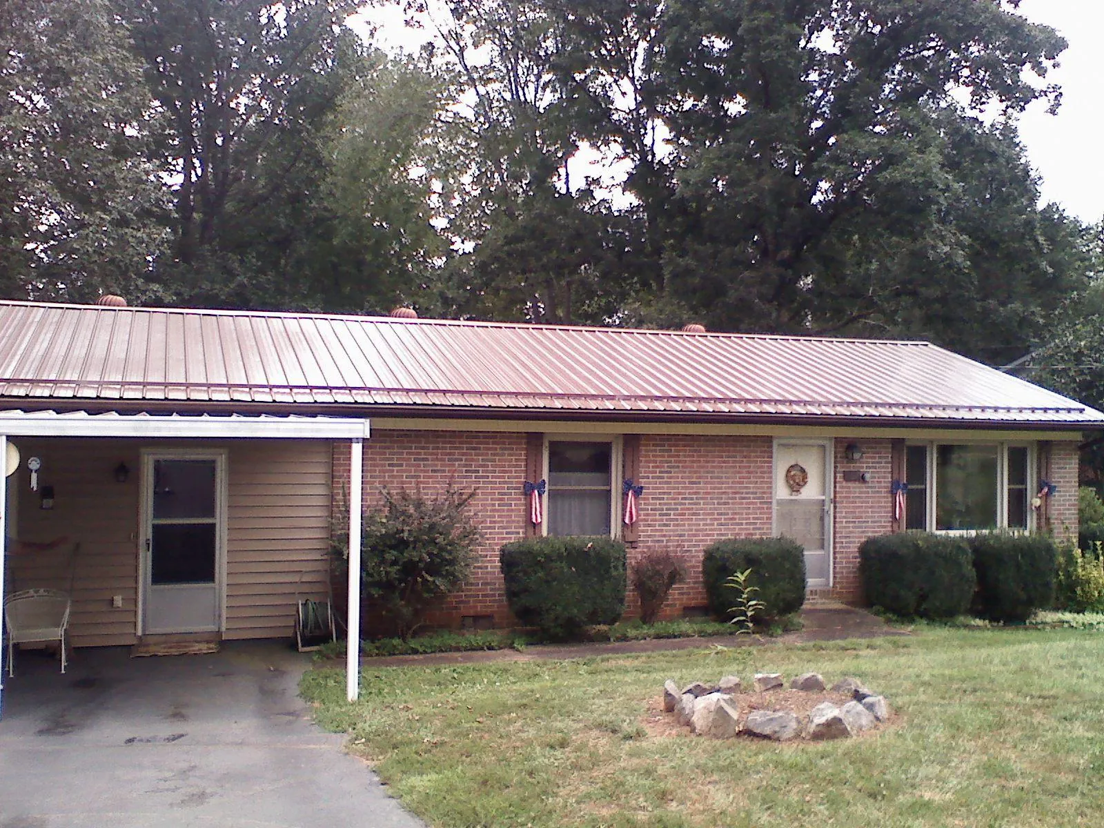 Bronze metal roof and carport on a brick ranch home — Roof Repair work by our crew in Gifford